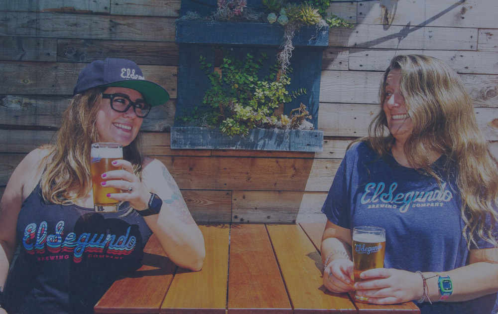 Two women drinking beer at a table